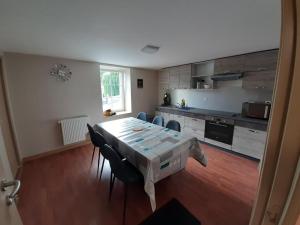 a kitchen with a table and chairs in a room at L'ANNEXE DE L'AMERIVIERE in Aubrives