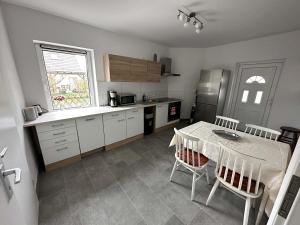 a kitchen with a table and a refrigerator and a table and chairs at Ruhige Monteurwohnung-Fewo für 4 Personen in Trebbin in Trebbin