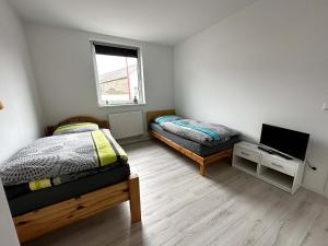 um quarto com duas camas e uma televisão em Ruhige Monteurwohnung-Fewo für 4 Personen in Trebbin em Trebbin
