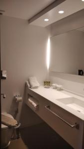 a bathroom with a sink and a mirror at Spetses Hotel in Spetses +37 photos