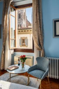 a room with a chair and a table and a window at Holiday AD Duomo, Florence in Florence