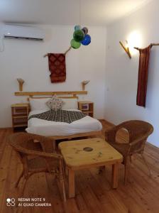 a bedroom with a bed and a table and a bed at Kfar Hanokdim - Desert Guest Rooms in Arad