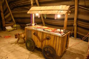 un cane in piedi accanto a un carretto di hot dog di Kfar Hanokdim - Desert Guest Rooms ad Arad
