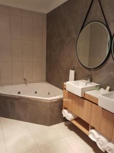 a bathroom with a tub and a sink and a mirror at Athena Studio Units in Roma