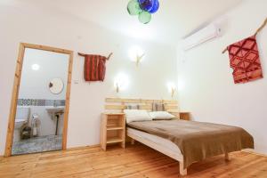 a bedroom with a bed and a mirror at Kfar Hanokdim - Desert Guest Rooms in Arad +38 photos