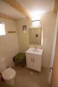 a bathroom with a white toilet and a sink at Kfar Hanokdim - Desert Guest Rooms in Arad