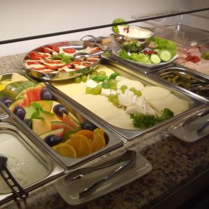a buffet with several trays of different types of food at Lieth-Hotel-Grünreich in Bad Fallingbostel