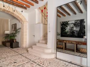 a hallway with a staircase in a house with a mirror at Can Verí Suites in Sóller