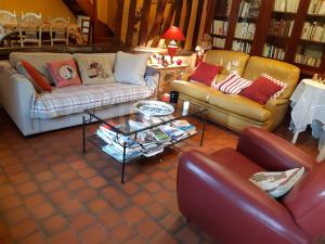 Sala de estar con 2 sofás y mesa de centro en les orchidees sauvages en Touffreville-la-Corbeline