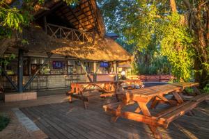 a group of picnic tables in front of a building at The Victoria Falls Waterfront in Livingstone