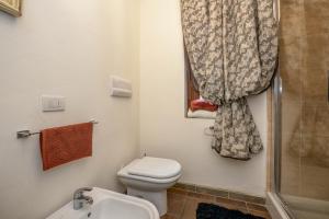 ein kleines Bad mit einem WC und einer Dusche in der Unterkunft Appartamento Orchidea in Gargnano