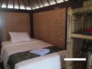 a small bed in a small room with a pillow at Selong Belanak Bungalows in Selong Belanak