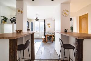 a kitchen with two bar stools and wooden counter tops at La "Tanière" pour 6 personnes in Isles-sur-Suippe +25 photos