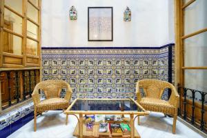 two chairs and a coffee table in a room at Hostal Austria in Granada