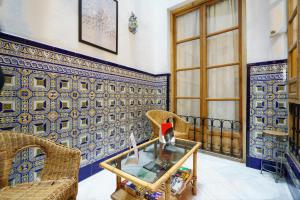 a living room with a glass table and blue and white tiles at Hostal Austria in Granada
