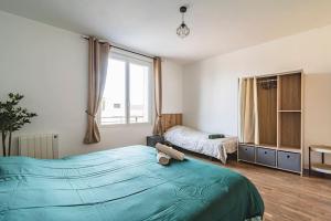 - une chambre avec un grand lit bleu et une fenêtre dans l'établissement La "Tanière" pour 6 personnes, à Isles-sur-Suippe