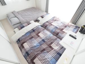 a bedroom with two beds and a couch at La Lumiere Oroku / Vacation STAY 1116 in Naha
