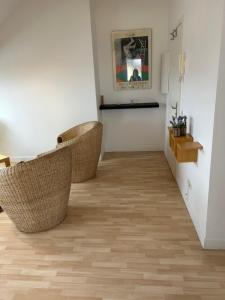 przedpokój z wiklinowymi krzesłami w pokoju w obiekcie Appartement - Stiring-Wendel w mieście Stiring-Wendel