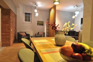 a dining room table with a vase of fruit on it at Heritage Apartment at Berindey French Villa, City Center, Bucharest in Bucharest