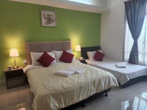 a bedroom with two beds with red and white pillows at The Viana Apartment 2 in Kota Bharu
