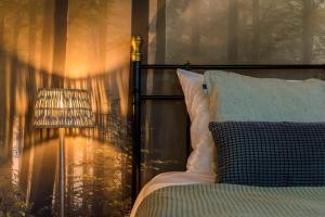 a bedroom with a bed and a lamp and a window at De Klokkenluider in Hollum