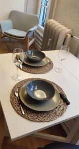 una mesa con dos platos y copas de vino. en Studio cosy, en Lons-le-Saunier