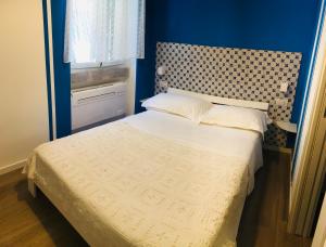 a small bedroom with a bed with a blue wall at B&B Via dell'Azzurra in Bari