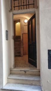 une porte ouverte menant à un couloir avec des escaliers dans l'établissement La piccola Perla, à Savone