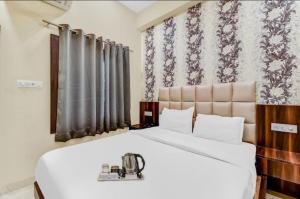 a bedroom with a large white bed with a machine on it at Hotel Dosa plaza in Udaipur