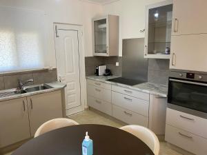 une cuisine avec une table, un évier et un comptoir dans l'établissement Villa Aiolos, à Loutraki