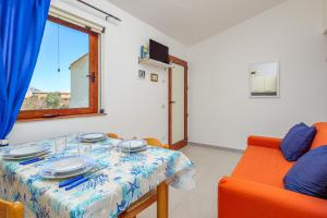 a dining room with a table and a couch at Casa Salina Bamba in San Teodoro