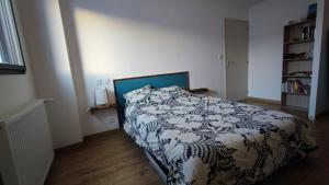 - une chambre avec un lit et une couette noire et blanche dans l'établissement Maison récente tout confort a proximité de la plage, à Pornichet