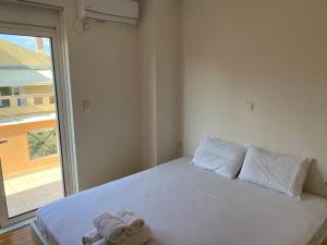 une chambre avec un lit blanc avec une fenêtre dans l'établissement Villa Aiolos, à Loutraki