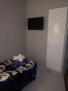a bedroom with a bed and a television on the wall at Hostal Conde de Lemos in Ponferrada
