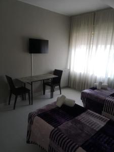 Pokój z 2 łóżkami oraz stołem i krzesłami w obiekcie Hostal Conde de Lemos w mieście Ponferrada