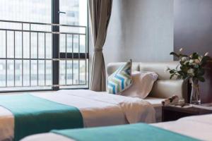 Habitación de hotel con 2 camas y ventana en Livetour Hotel Kehui Golden Valley Guanzhou, en Guangzhou