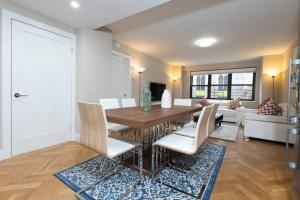 ein Wohnzimmer mit einem Holztisch und Stühlen in der Unterkunft Elegant East Side in New York