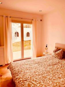 een slaapkamer met een bed en een groot raam bij Villa mit Meerblick und Pool für 6 Personen in Santanyi