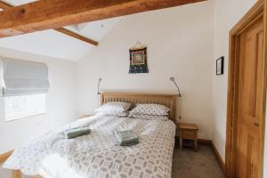 1 dormitorio con 1 cama y reloj en la pared en ELM HOUSE BARN - Converted One Bed Barn at the gateway to the Lake District National Park en High Hesket