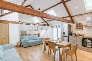 High HesketにあるELM HOUSE BARN - Converted One Bed Barn at the gateway to the Lake District National Parkのリビングルーム(テーブル、ソファ付)