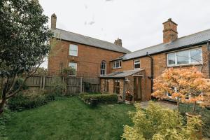 a brick house with a yard in front of it at ELM HOUSE BARN - Converted One Bed Barn at the gateway to the Lake District National Park in High Hesket