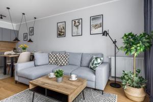 a living room with a couch and a table at Wellness & SPA Resort Dziwnów Apartments with Parking by Renters Prestige in Dziwnów