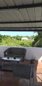 a patio with a table and chairs on a porch at Corinne Villa à 300m from the beach in Grand Baie