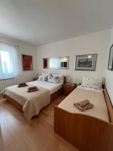een slaapkamer met 2 bedden en handdoeken bij Apartman Stipić 1 in Baška Voda