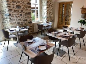 a restaurant with tables and chairs in a room at La Maison du Bonheur in Ausson