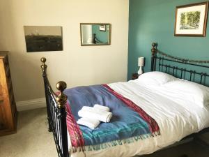 a bedroom with a bed with towels on it at Grand top floor apartment in the Royal Bank House in Maybole
