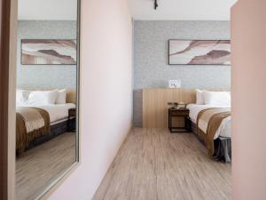 鵝鑾的住宿－宅屋Jhai-Wu ，配有2张床的酒店客房内的镜子