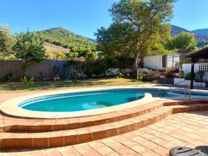 a swimming pool with a brick retaining wall around it at Villa La Loma in Alhaurín de la Torre