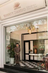 um homem parado na porta de uma loja em Serenity Diamond Hotel 1E Cửa Đông - by Bay Luxury em Hanói