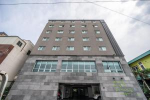 a tall gray building with a tunnel in it at Hotel Rest Seogwipo in Seogwipo